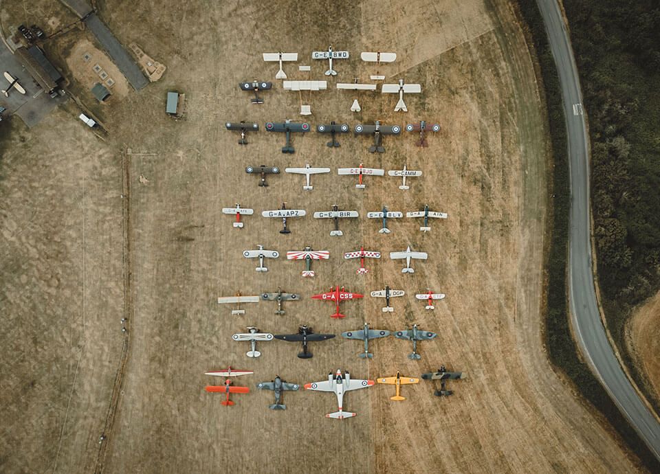 Aerial view of vintage aircraft arranged on a grass airfield
