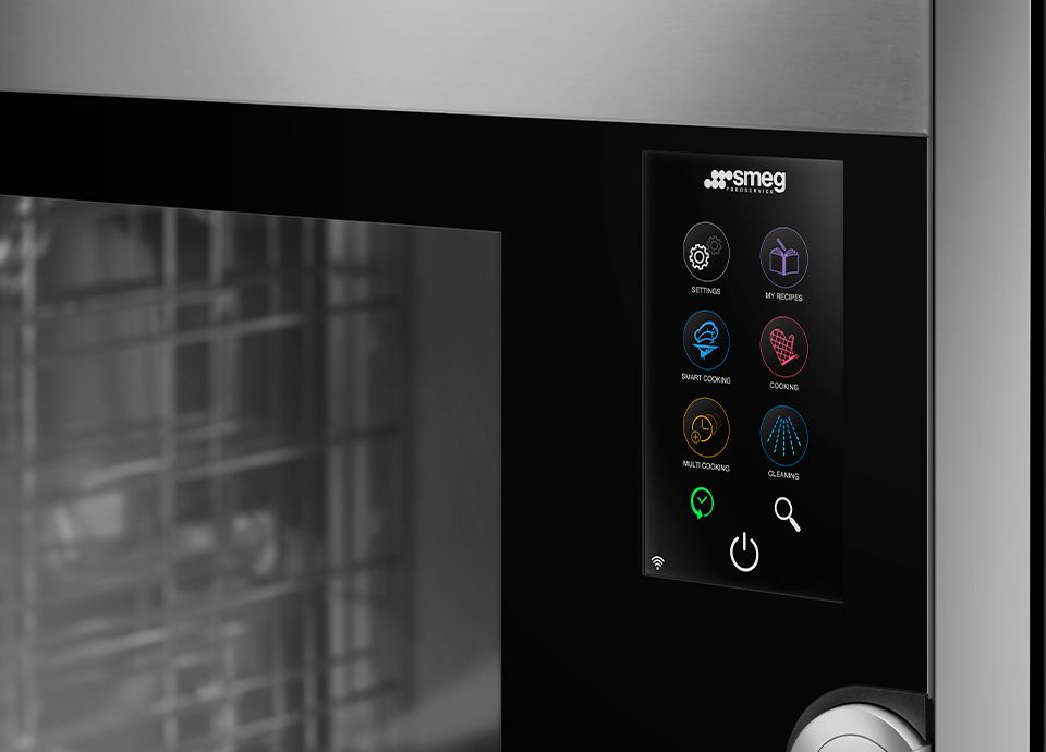 Smeg oven with 7-inch full-touch display showing interface icons for settings, smart cooking, cleaning, and more