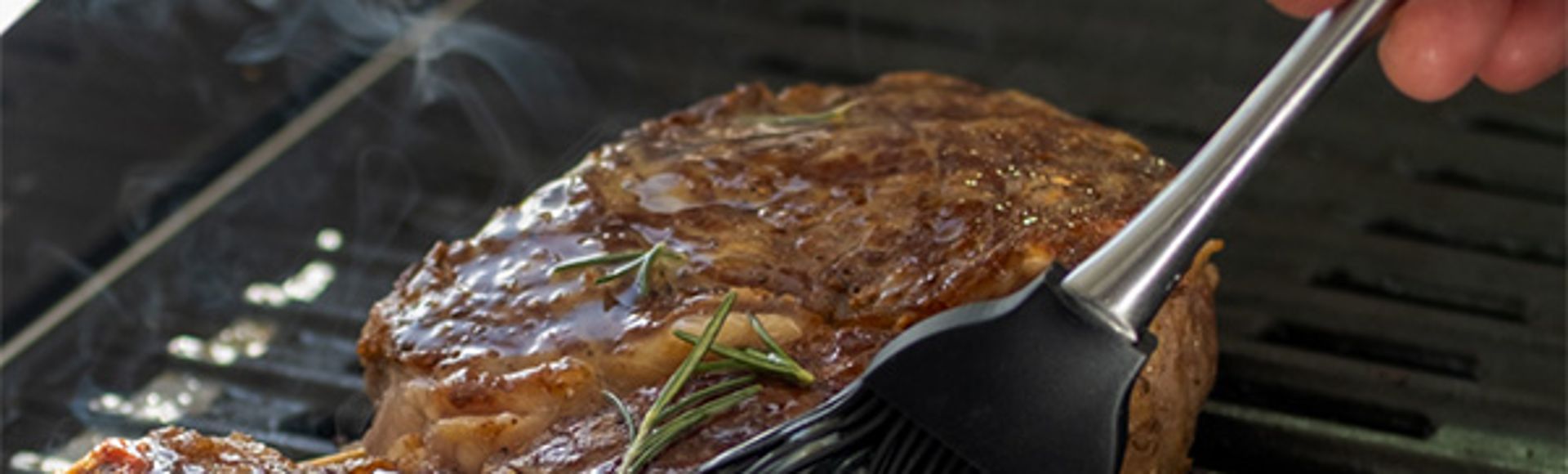 steak being basted on a SMEG eBBQ 60cm grill