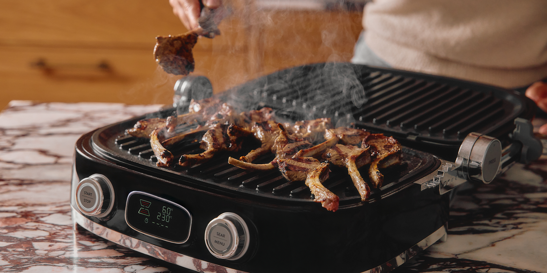 Multigrill in Black as an open face BBQ with succulent pork chops cooking and smoke
