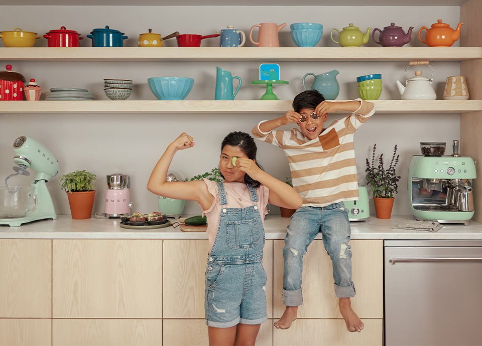 Two children in front of a kitchen filled with Pastel Green small appliances