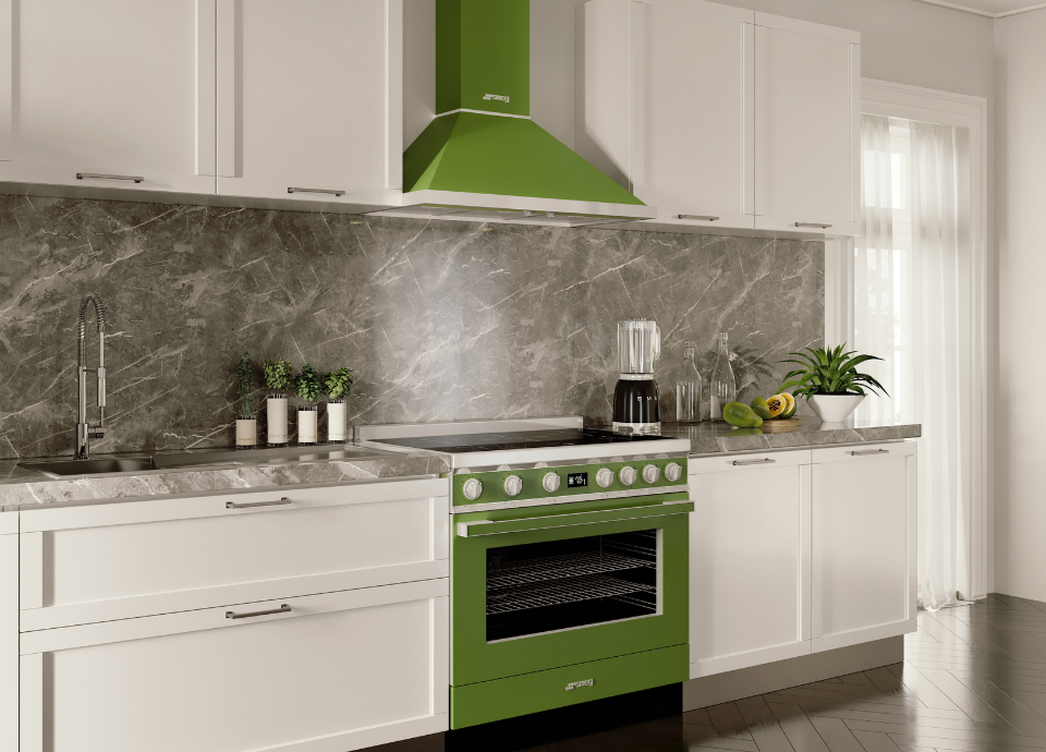Piano de cuisson Smeg esthétique Portofino de couleur vert olive, largeur 90 cm, intégré dans une cuisine contemporaine aux façades blanches. Doté d’une large table de cuisson, d’un grand four multifonction, de manettes métalliques et d’un afficheur numérique central, le piano constitue l’élément principal de la composition. Au-dessus, une hotte décorative assortie complète harmonieusement l’ensemble. À proximité, un plan de travail effet pierre, un évier avec mitigeur chromé, des plantes aromatiques et de petits appareils électroménagers