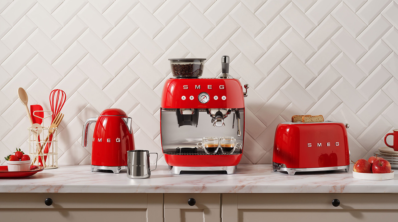 Ensemble de petit-déjeuner rouge Smeg. Bouilloire rouge, grille-pain rouge et machine à café rouge sur un plan de travail.