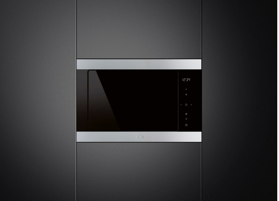 Four micro-ondes encastrable Smeg avec façade noire, bandes supérieure et inférieure en inox, présenté sur fond noir avec un éclairage mettant en valeur son design moderne