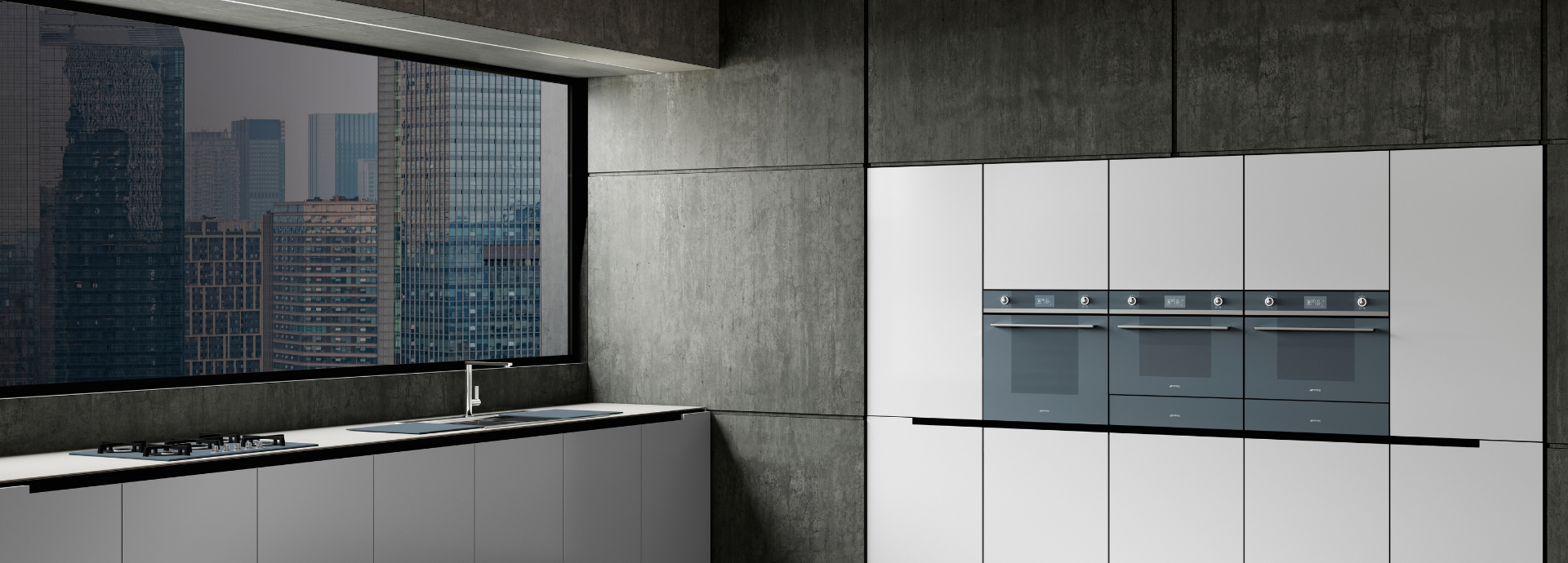 Trois fours encastrables Smeg en finition noire et chromée, intégrés dans une cuisine moderne grise avec une grande fenêtre offrant une vue sur des immeubles en ville. Les trois fours sont installés à droite de l’aménagement. Sous la fenêtre se trouve une plaque de cuisson à gaz équipée d’un robinet, posée sur un plan de travail contemporain.