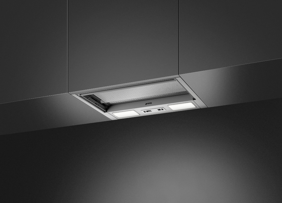 Hotte intégrée esthétique Smeg Universel en inox et installée dans un meuble de cuisine gris foncé. La hotte est présentée avec un éclairage mettant en valeur son design moderne