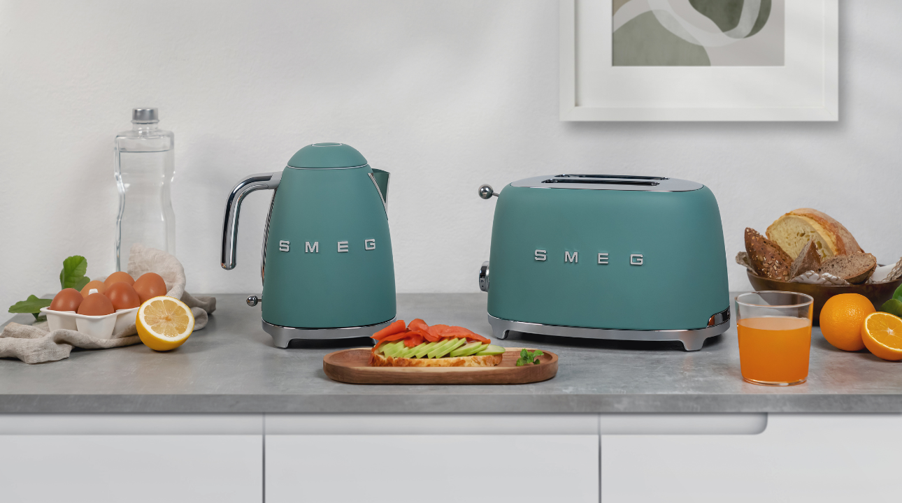 Ensemble de petit-déjeuner bouilloire vert émeraude mat et grille-pain SMEG sur un plan de travail.