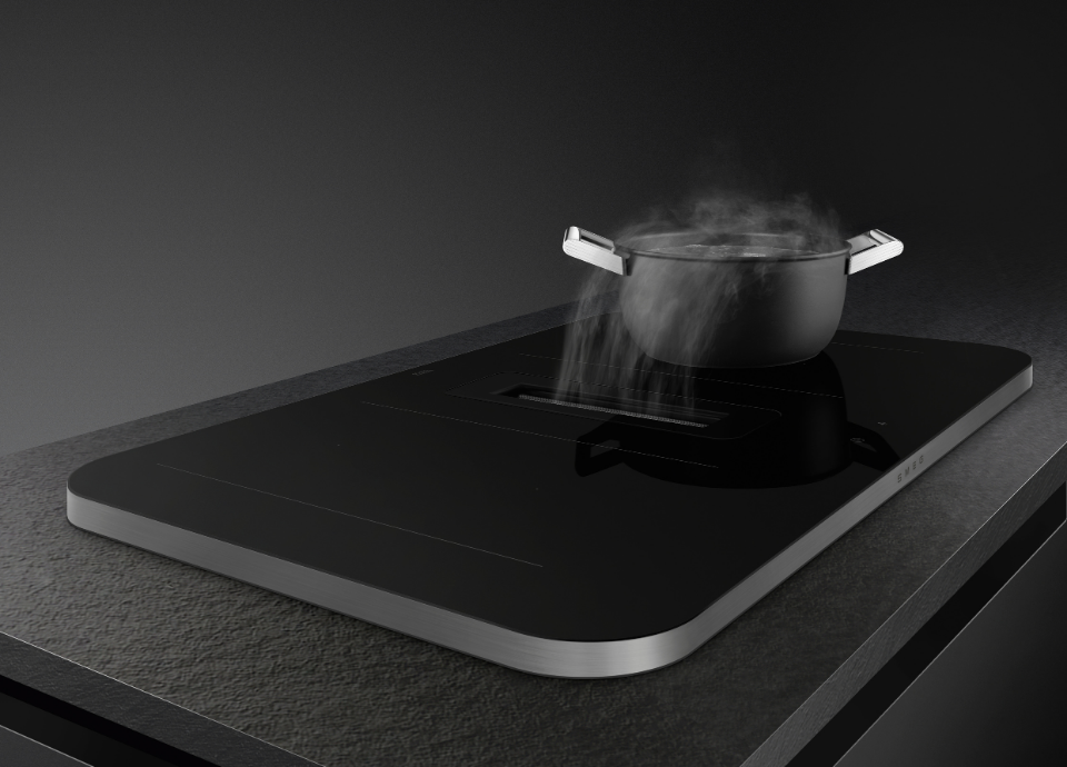 Plaque de cuisson induction Smeg en contour inox avec surface noire, intégrée sur un plan de travail mat. Le fond de l'image est noir, créant un contraste élégant entre l’inox, les grilles noires et les surfaces sombres.