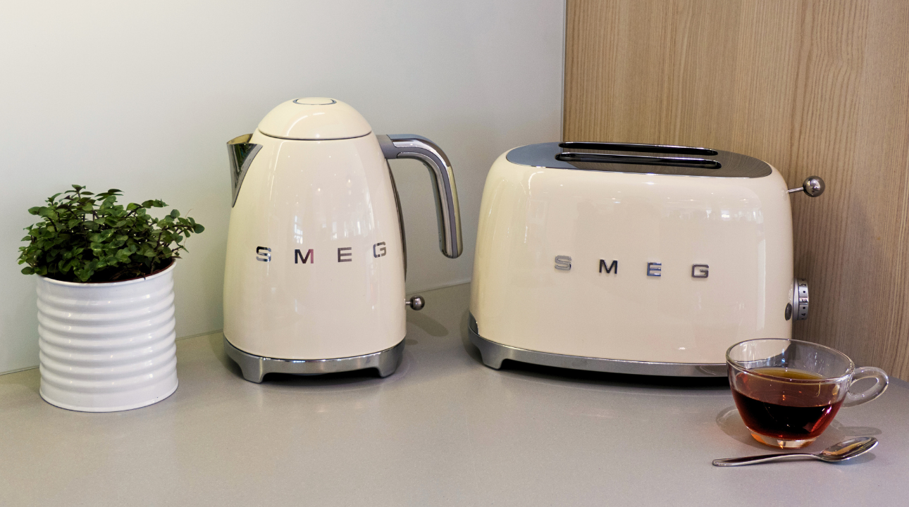 Ensemble petit-déjeuner SMEG bouilloire beige et grille-pain sur un plan de travail.