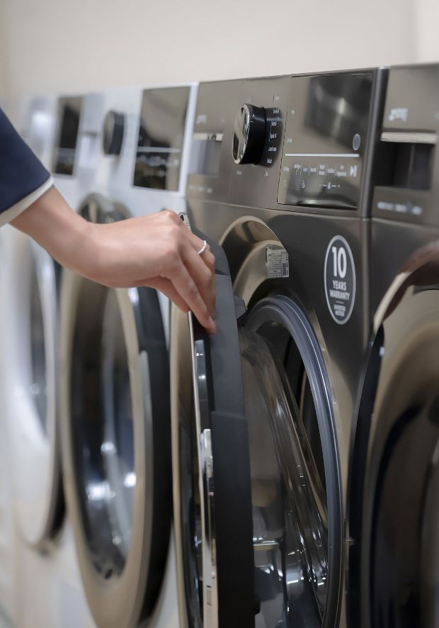 Profissional especializado a apresentar as funcionalidades das máquinas de lavar roupa Smeg