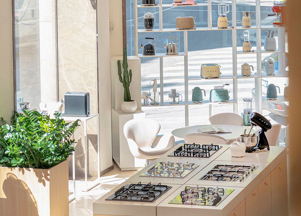 Area espositiva interna dello SMEG Store Milano con grandi e piccoli elettrodomestici