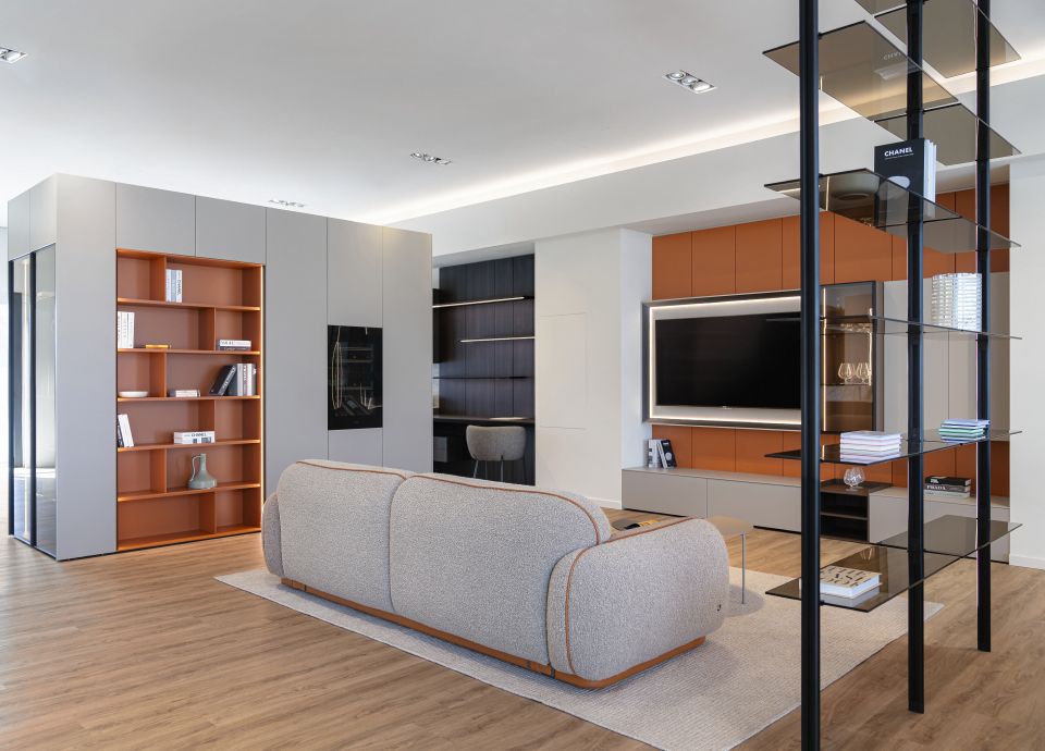 Soggiorno moderno composto da divano, parete tv e libreria a vista