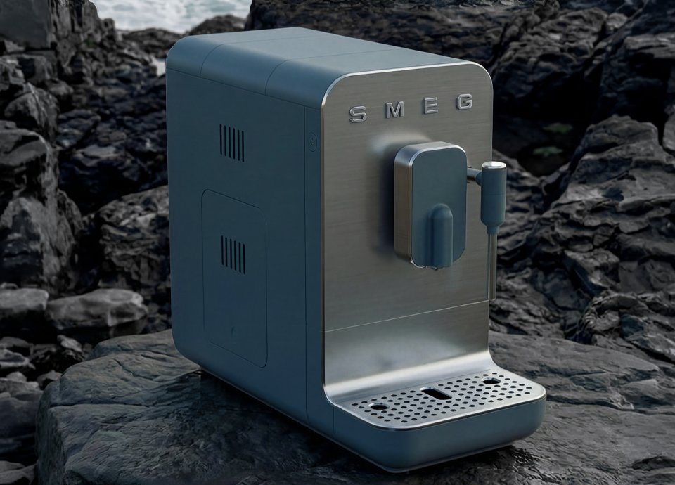 Air Fryer Smeg na cor Storm Blue, com um design compacto e contemporâneo, painel frontal em vidro escuro e topo metálico, enquadrada por uma paisagem costeira rochosa onde o mar reforça a inspiração natural da tonalidade.