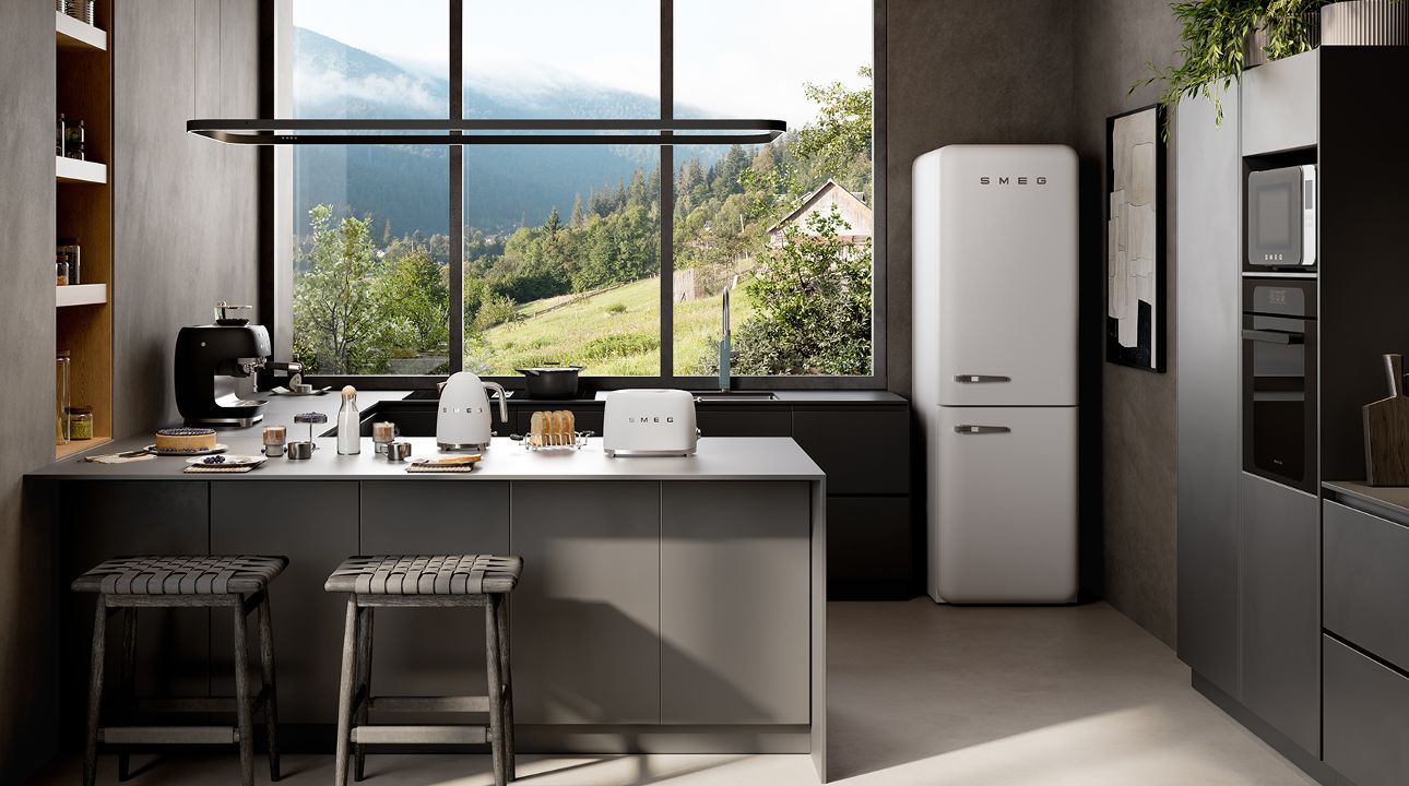 Modern kitchen interior featuring a matt black SMEG refrigerator alongside small countertop appliances in matte white finish, set against a warm brown wall with open shelves, plants, and a metallic cabinet base.