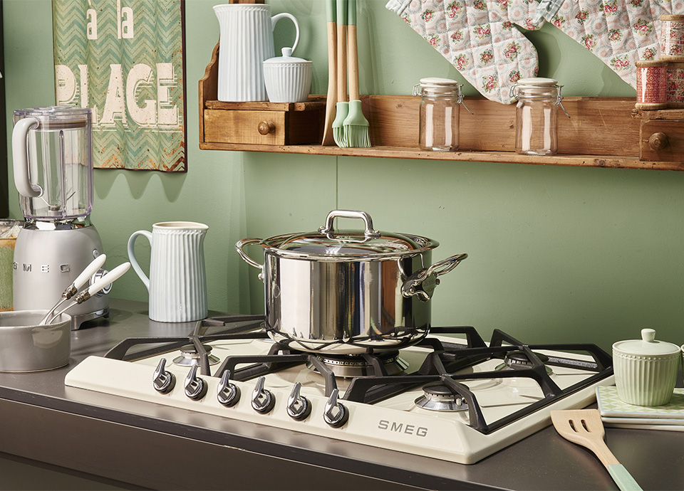 A cream gas hob in a Victoria design with cookware