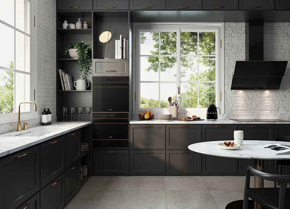 large kitch with dark units, white marble worktop and two of Smeg's built in ovens in column arrangement