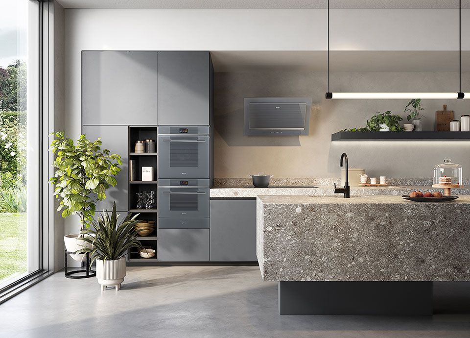 A contemporary kitchen with modern grey, handle-less units, and two of Smeg's built-in single ovens in a column arrangement