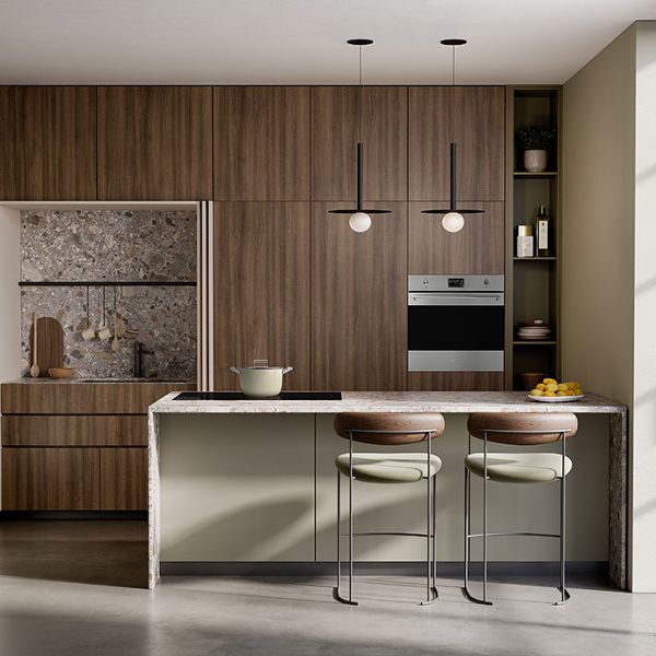A contemporary kitchen featuring one of Smeg's built-in single ovens (stainless steel) integrated within dark wood floor-to-ceiling kitchen cabinets