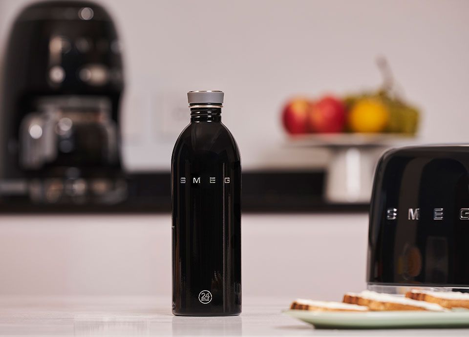 Black Smeg water bottle on kitchen unit with black smeg toaster and drip coffee machine