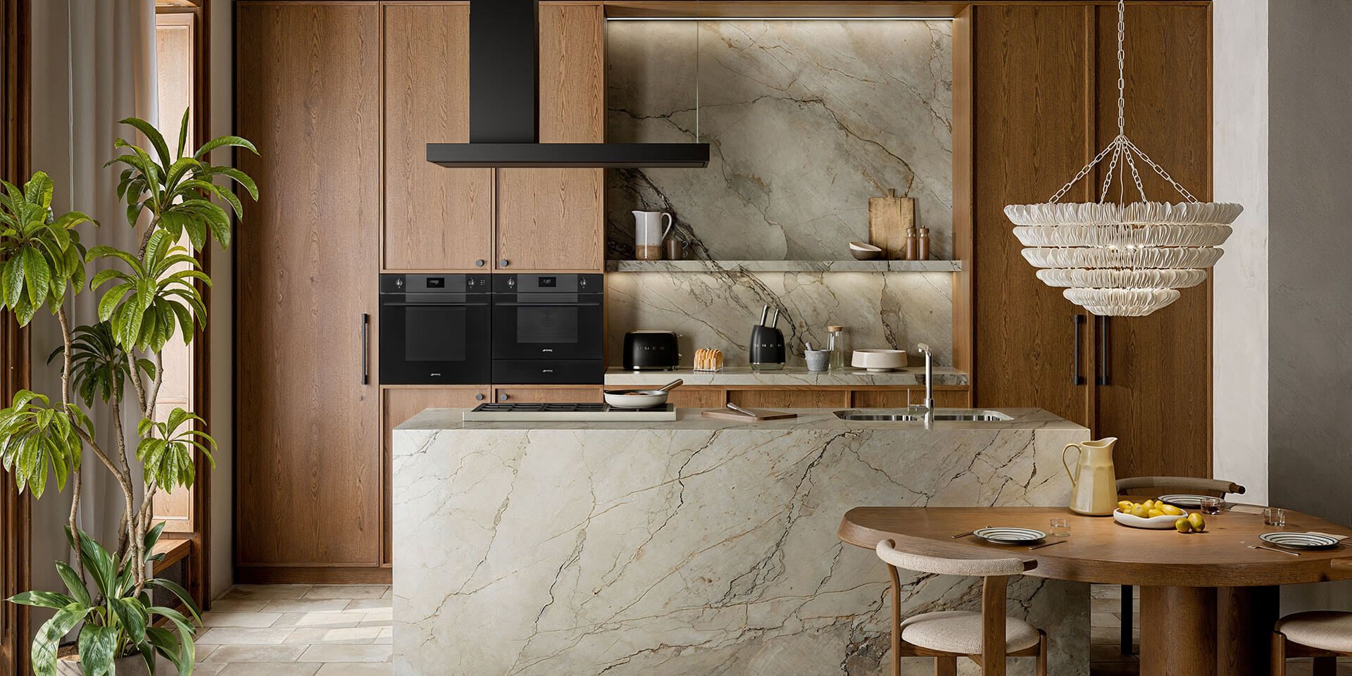 Modern kitchen with marble island, black appliances and wooden table