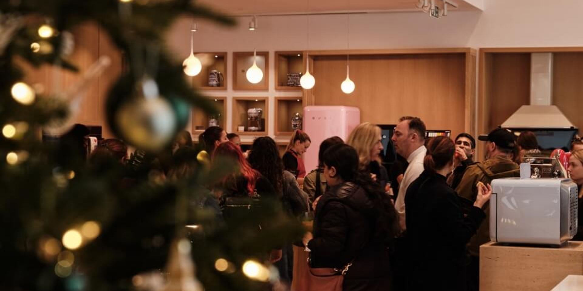 A festive image of the event featuring guests and a pink fab fridge.