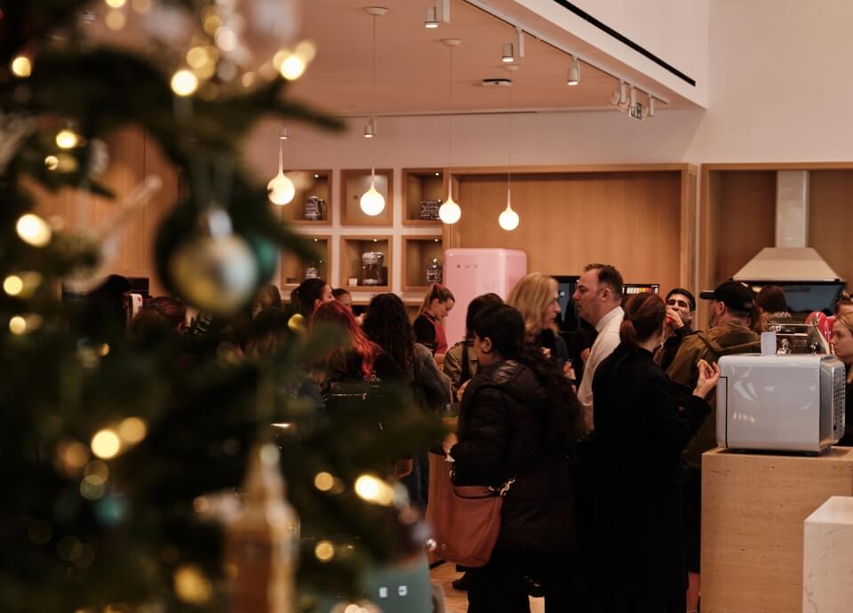 A festive image of the event featuring guests and a pink fab fridge.
