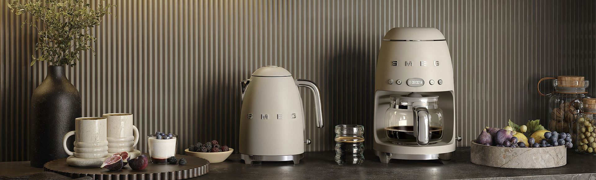 Moonlight SMEG refrigerator next to a matching drip filter coffee machine on a stone plinth, against a neutral textured background in a minimalist setting
