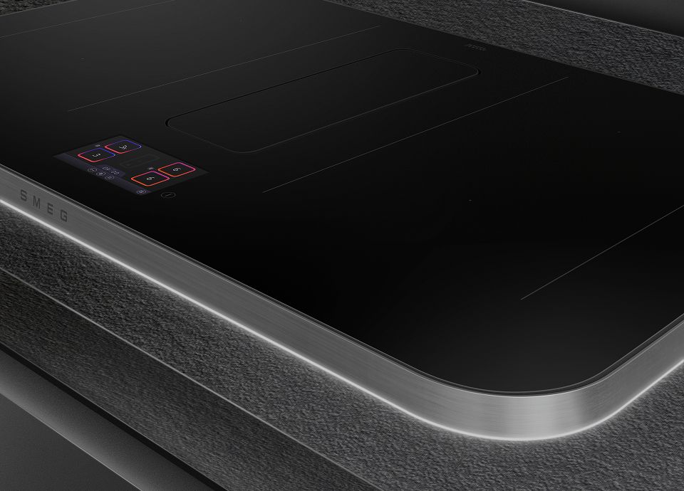 Closeup of SMEG Isola hob that shows soft edges, a 2-cm brushed anodised aluminum frame and the integrated light around it