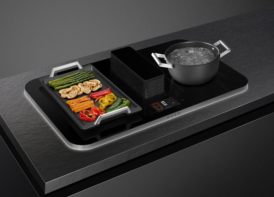 The image shows the smart functions on the SMEG Isola hob with different meals cooking