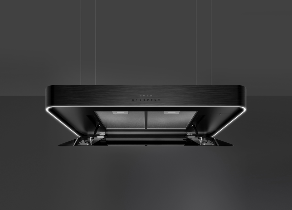 Vista inferior de um exaustor Smeg Isola preto com painel de vidro aberto, revelando os filtros e a iluminação interna.