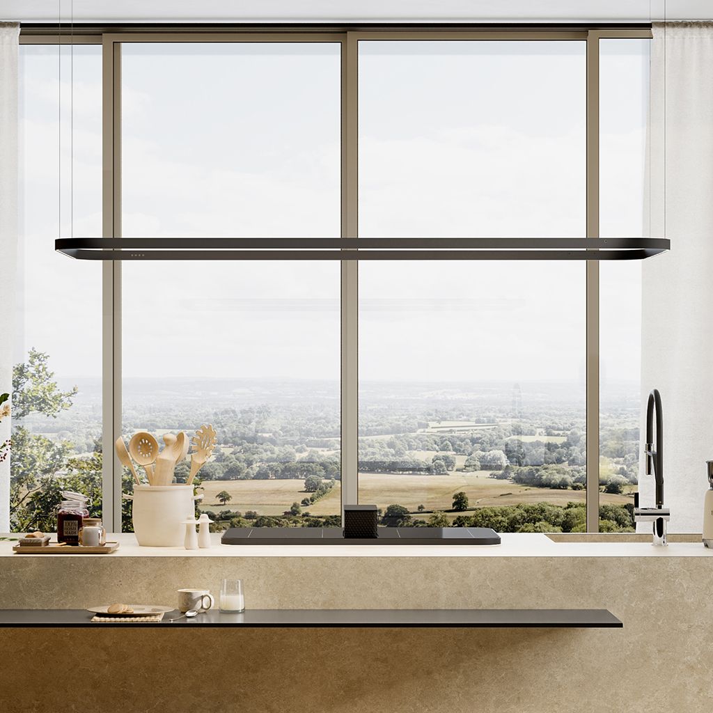 Lighting rail suspended horizontally over a kitchen island, positioned in front of a large window with a panoramic countryside view.
