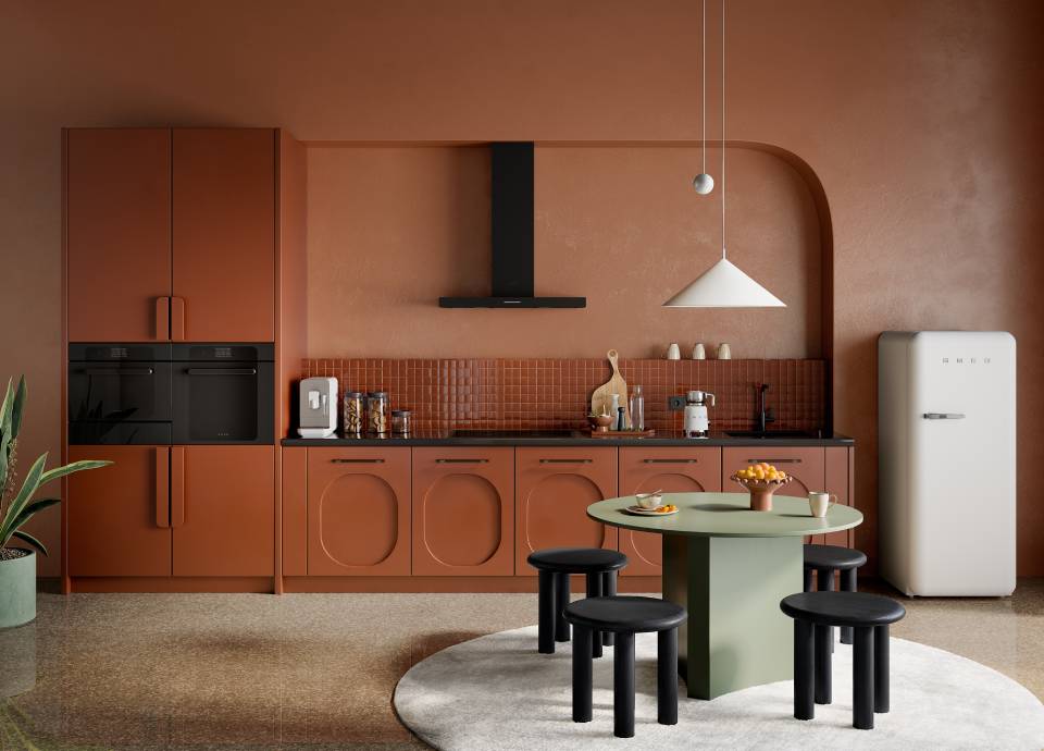 Earthy terracotta-colored kitchen featuring integrated black appliances and matching arched cabinetry.