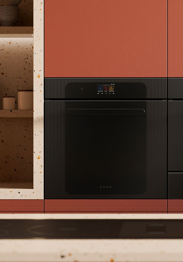Close-up of black built-in SMEG ovens built into matte red cabinetry
