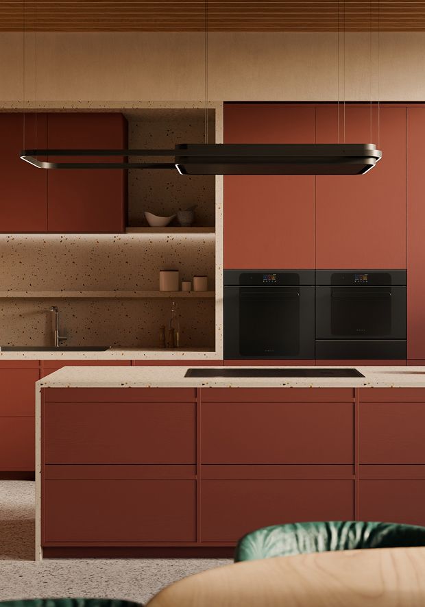 Red minimalist kitchen with a large island, induction hob, and wooden ceiling panels.