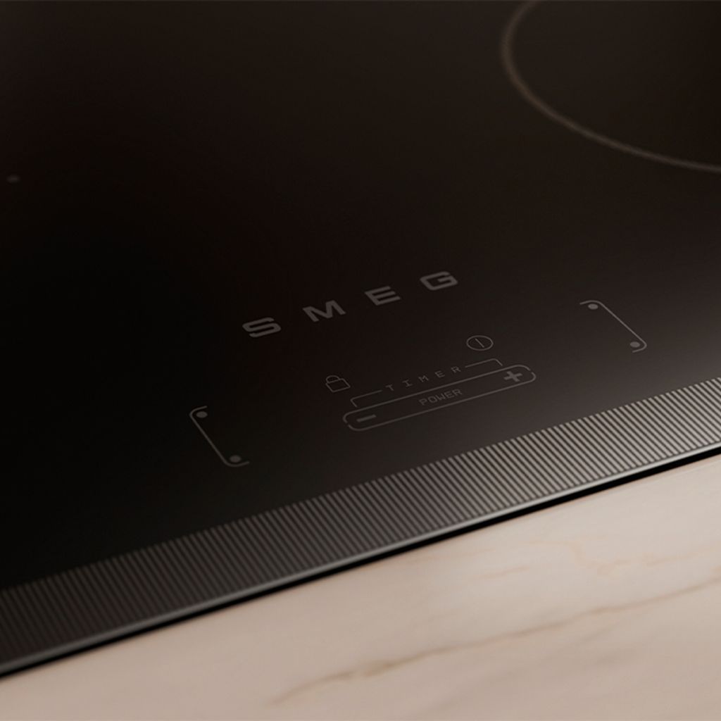 Closeup of a black induction hob on a greige kitchen countertop