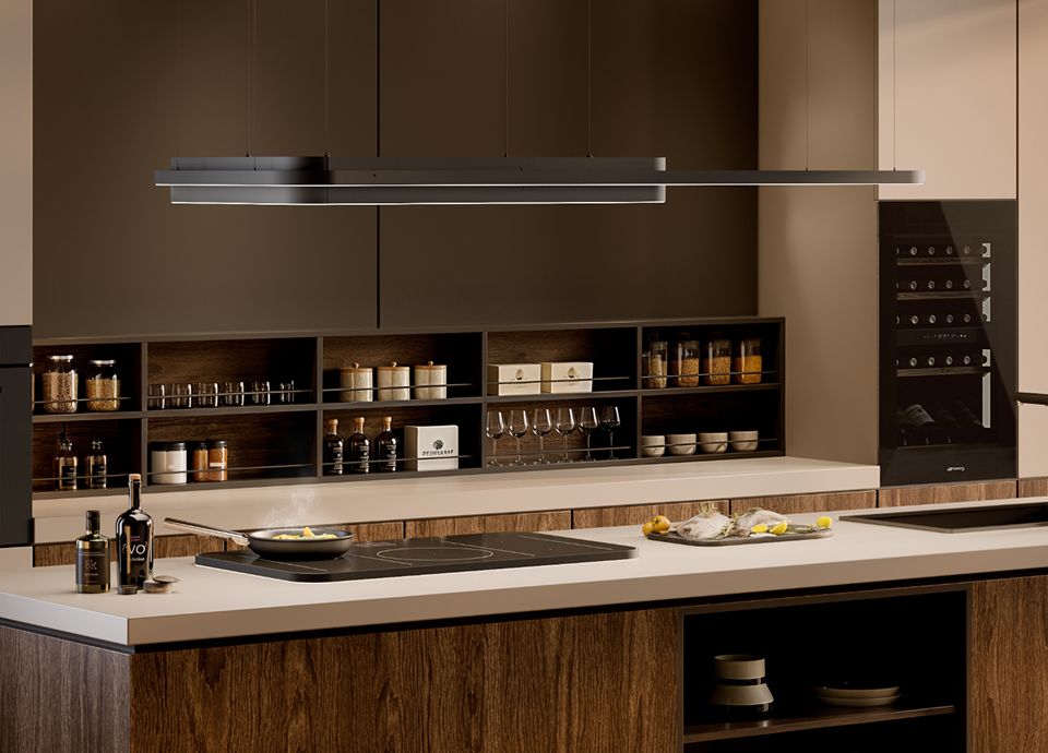 Cuisine moderne dotée d'une plaque à induction épurée intégrée à un îlot central, surmontée d'une hotte suspendue minimaliste, entourée de meubles en bois, d'étagères ouvertes accueillant des accessoires de cuisine et d'une cave à vin encastrée.