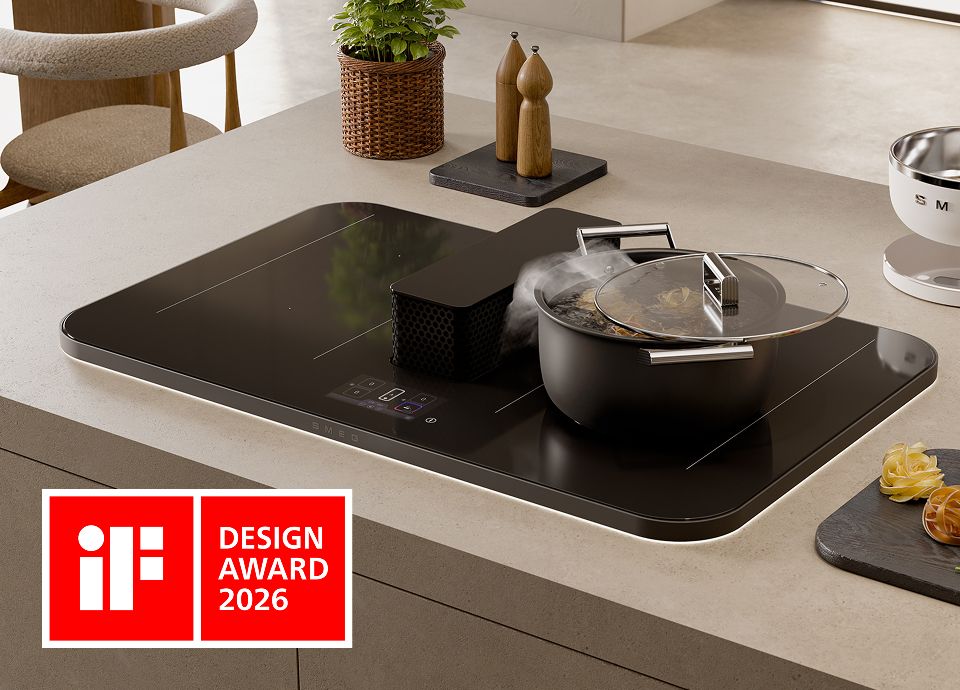 Plaque à induction noire avec hotte aspirante centrale intégrée, installée dans un îlot de cuisine ; une casserole munie d'un couvercle en verre dégage de la vapeur pendant la cuisson, le logo « iF Design Award 2026 » étant visible.