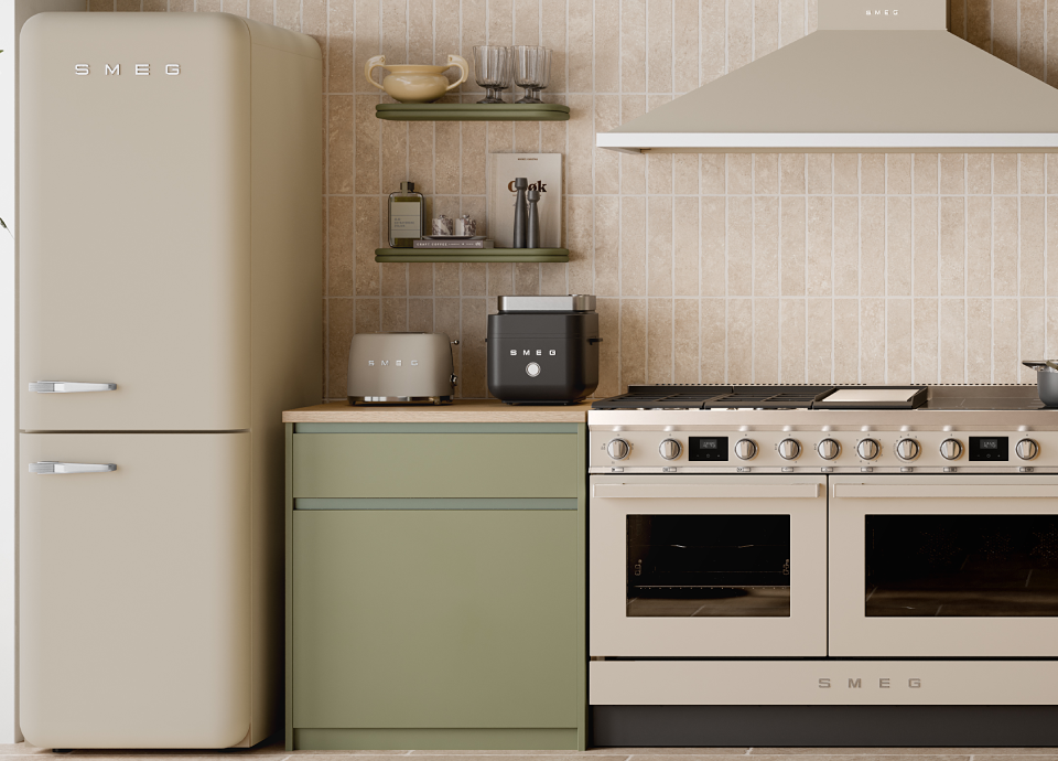 Smeg black air fryer on a countertop in a warm-toned kitchen with beige tiles, sage green cabinets and coordinated appliances