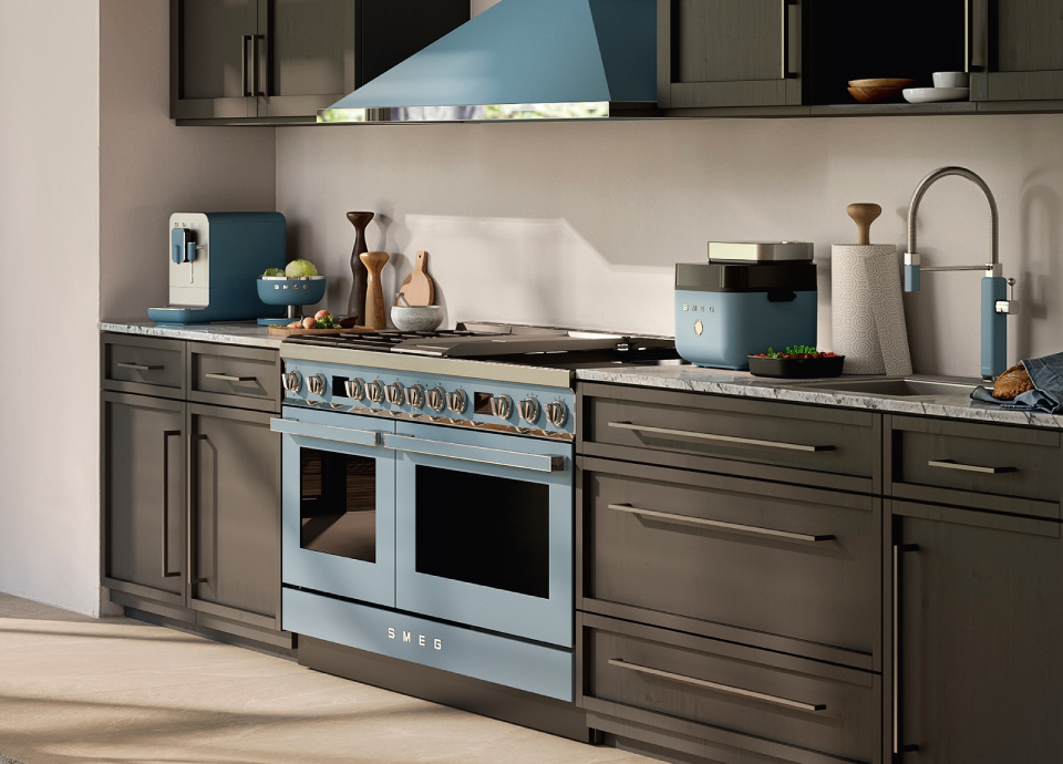 Smeg blue air fryer on a kitchen countertop with grey cabinetry, marble worktop and coordinated blue appliances
