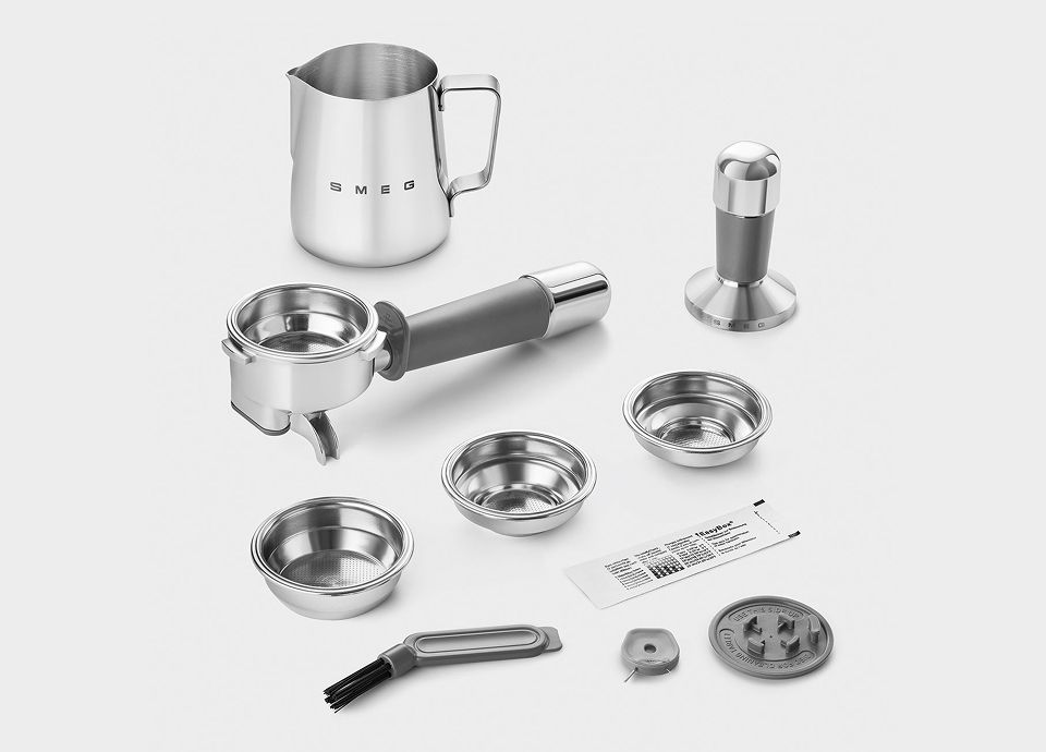 Set of stainless steel accessories for a manual coffee machine including portafilter, filters, tamper, milk jug, cleaning brush, and components