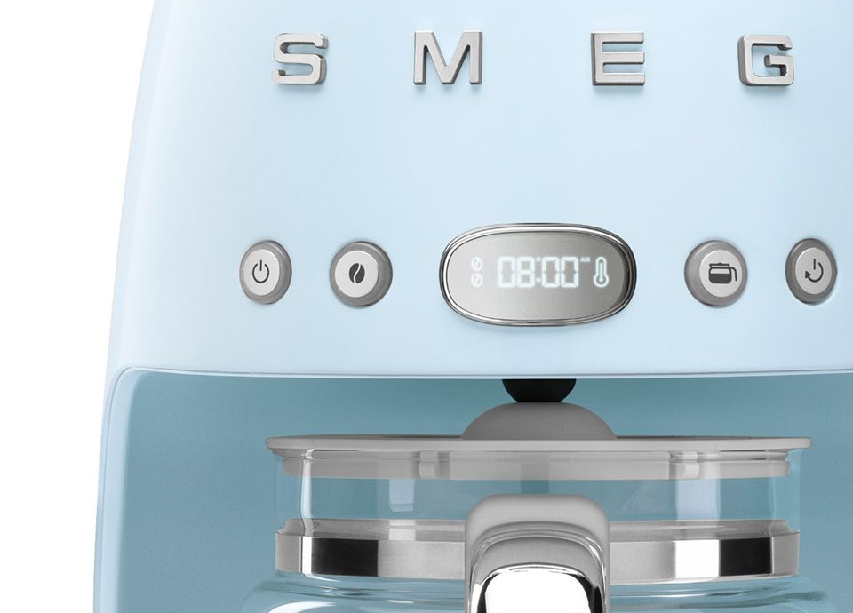 Close-up of a pastel blue drip coffee machine showing the LED display, function buttons, and glass carafe handle.
