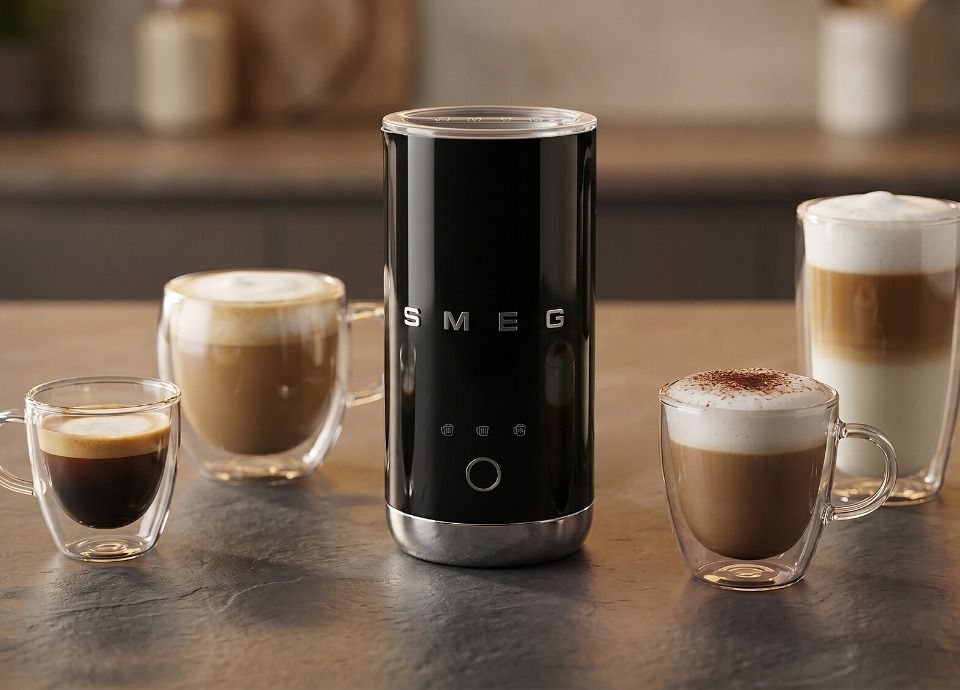Black SMEG milk frother surrounded by espresso, cappuccino and latte glasses on kitchen countertop
