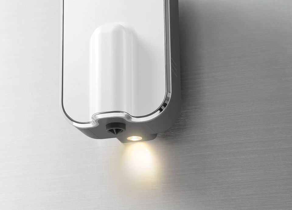 Close-up of an illuminated and height-adjustable Smeg coffee machine brewing unit with integrated light