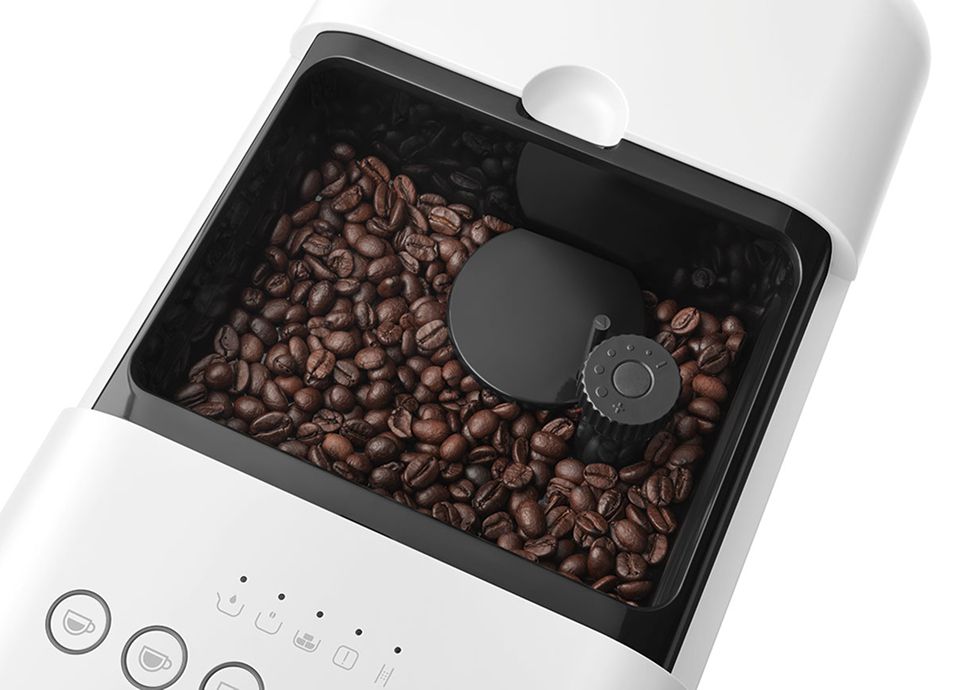 Top view of Smeg coffee machine bean hopper filled with coffee beans and integrated grinder adjustment dial