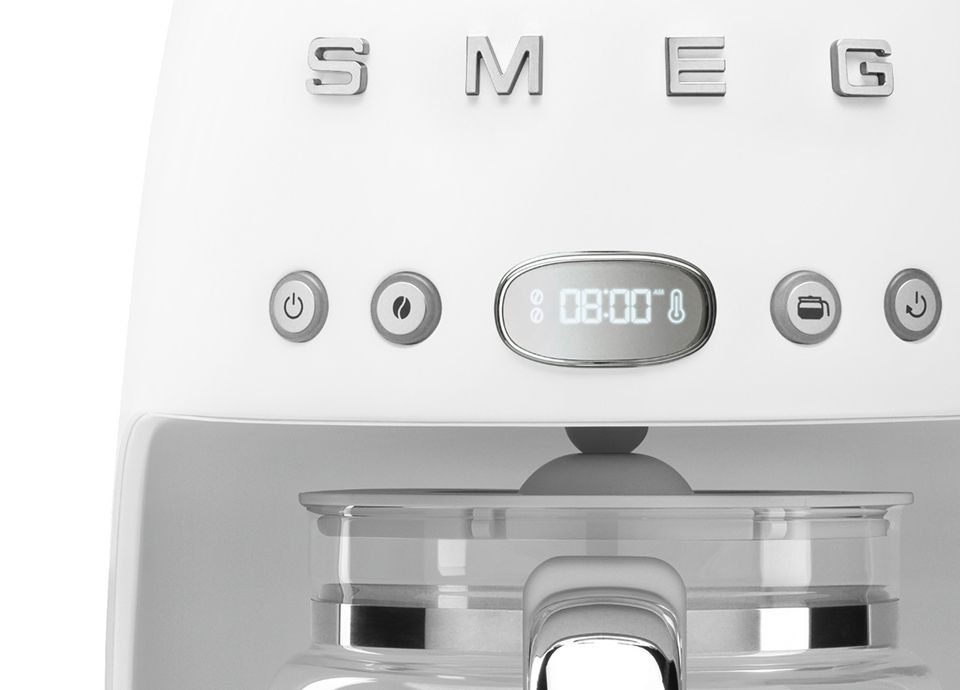 Primo piano di una macchina da caffè a goccia con finitura opaca, che mostra il display a LED, i pulsanti funzione e il manico in vetro della caraffa.