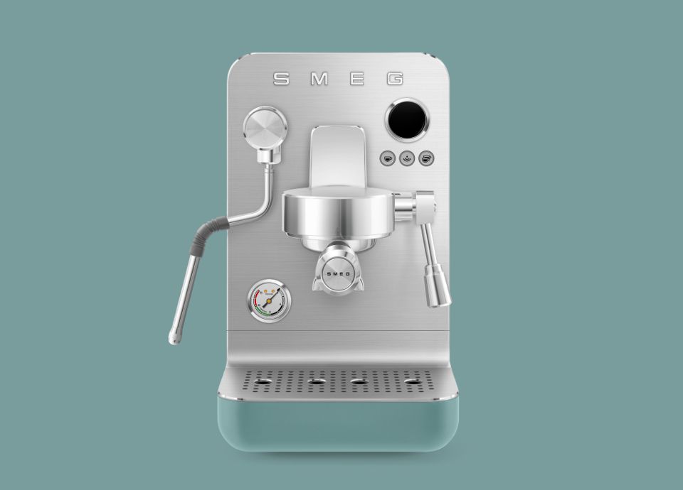 Macchina da caffè espresso SMEG mini pro con finitura verde smeraldo opaca, corpo in acciaio inox e lancia vapore.