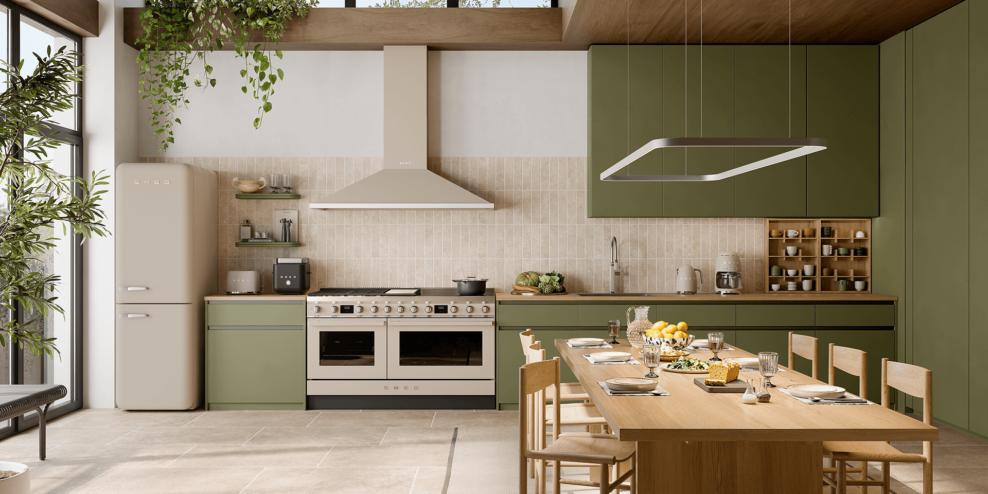 Bright contemporary kitchen featuring SMEG appliances in matt moonlight finish, including a range cooker, extractor hood, and retro-style refrigerator, set within green cabinetry, warm wood accents, and a large dining table under natural light.