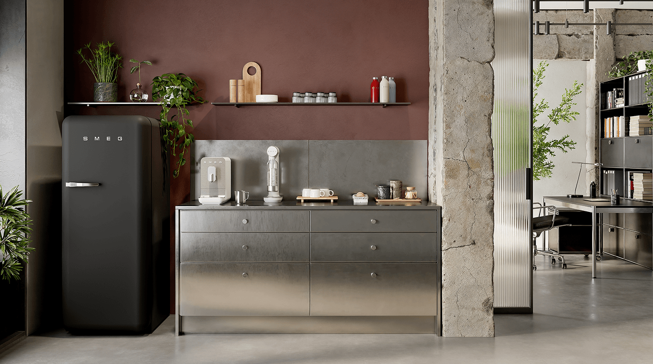 Modern kitchen interior featuring a matt black SMEG refrigerator alongside small countertop appliances in matte white finish, set against a warm brown wall with open shelves, plants, and a metallic cabinet base.