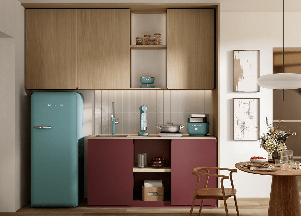 Un espace de vie lumineux et polyvalent, équipé d'appareils électroménagers SMEG au fini vert émeraude, notamment un réfrigérateur de style rétro et de petits appareils de cuisine posés sur un buffet en bois, jouxtant un espace de remise en forme doté d'équipements de gym, d'un parquet en bois clair et de grandes fenêtres ornées de voilages.