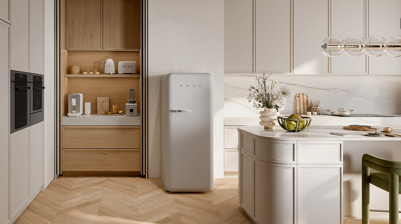Bright, minimal kitchen featuring SMEG appliances in matt white finish, including a retro-style refrigerator and small countertop appliances, set within light cabinetry, warm wood accents, and a central island under soft natural light.